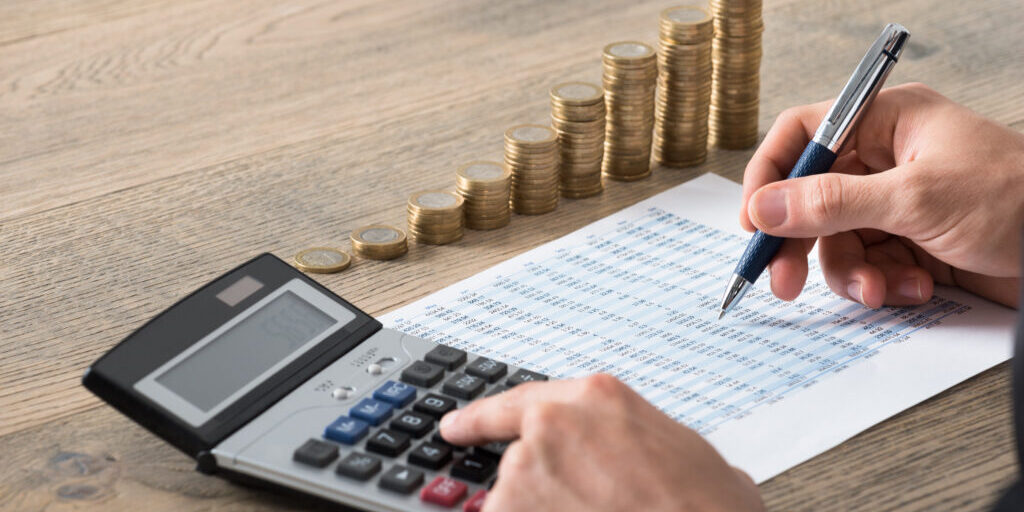 man i kostym som räknar på sina timmar och kostnader