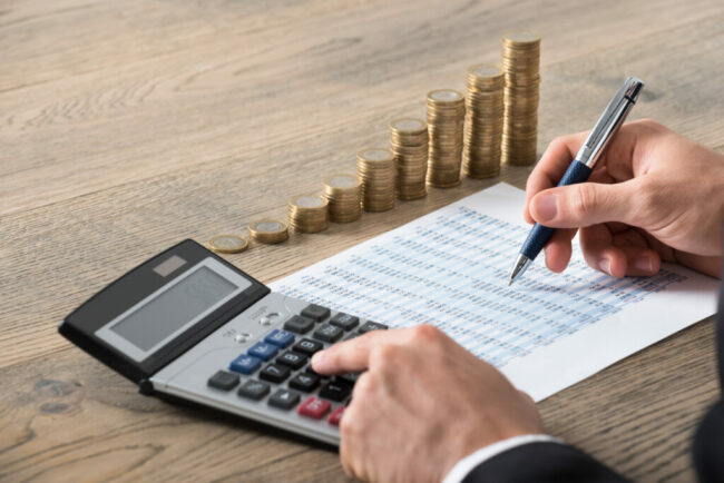 man i kostym som räknar på sina timmar och kostnader