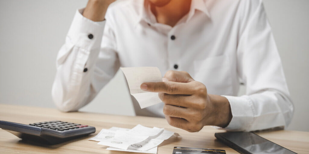 En man som tittar på sina kvitton och räknar på sina utlägg