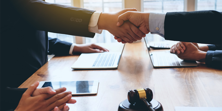 Personer som skakar hand, illustrerande att ett avtal slut.